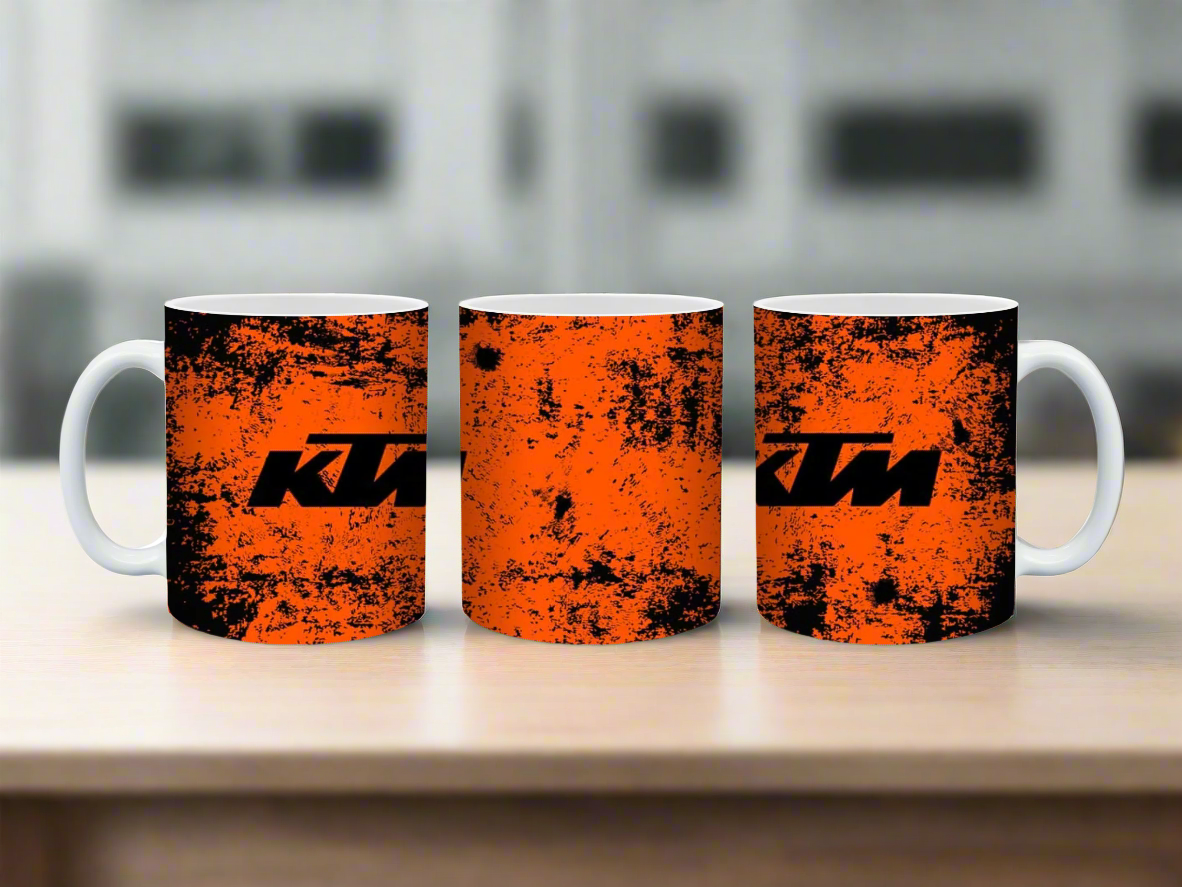 Three KTM branded mugs with orange and black design on a white background