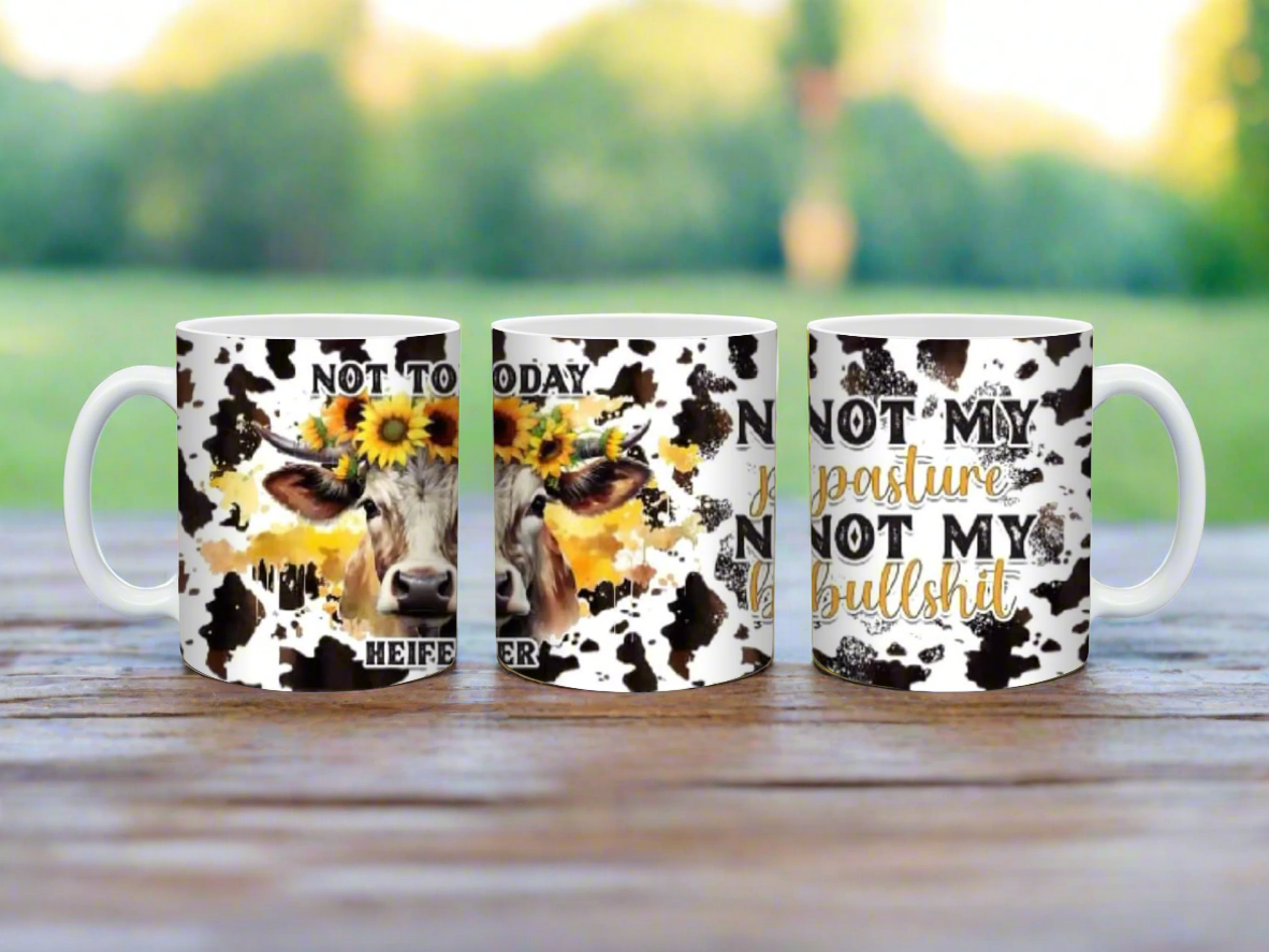 Three cow-themed mugs with floral designs and text on a white background
