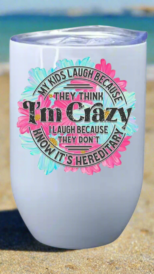 Tumbler with colorful text design on a beach